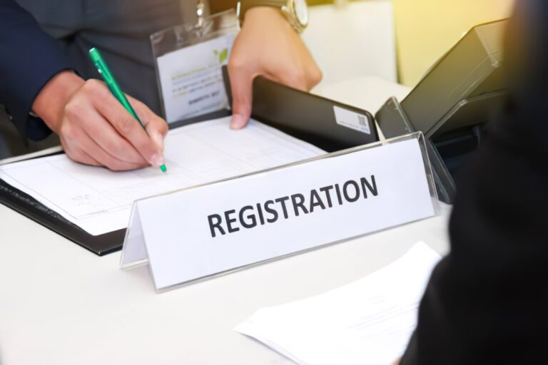 a woman is writing on a registration paper for a business man